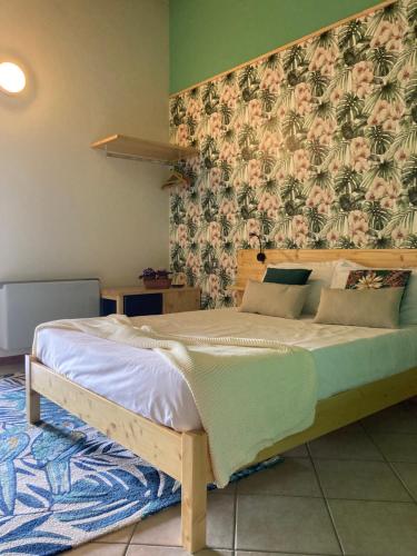 a bedroom with a large bed with a floral wallpaper at Locanda del Borgo in Prunetto