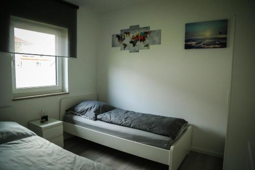 a small bedroom with a bed and a window at Ferienwohnung Air-Base - Playmobil, Messe, Nürnberg, Fürth, Ansbach in 20 Minuten erreichbar in Großhabersdorf