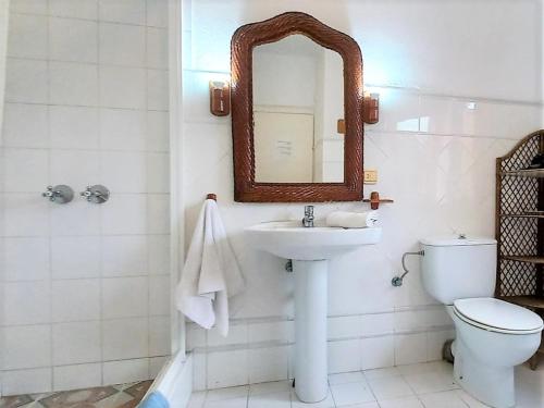 a bathroom with a sink and a toilet and a mirror at Exclusive holiday home in Siesta with private pool in Santa Eularia des Riu