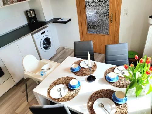 a white dining room table with chairs and a washing machine at Ferienwohnung Xxl Lausitz direkt in Radibor