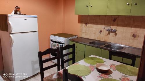 a kitchen with a table and a white refrigerator at Porto Sabatiki in Sampatiki
