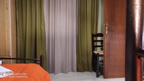 a bedroom with a bed and green curtains at Porto Sabatiki in Sampatiki