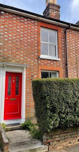 a brick house with a red door and a window at Cosy 2 bedroom Victorian cottage, Newport, Isle of Wight in Newport
