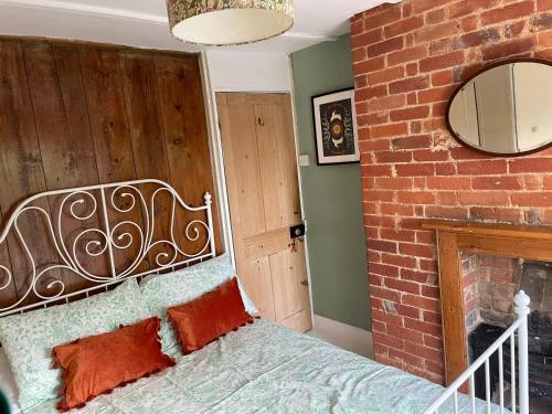 a bedroom with a bed and a brick wall at Cosy 2 bedroom Victorian cottage, Newport, Isle of Wight in Newport