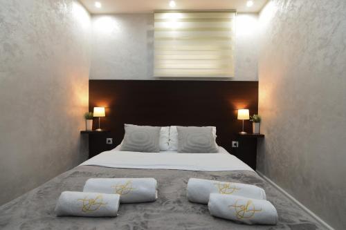 a bedroom with a large bed with two pillows on it at GardenLux Vrdnik in Vrdnik