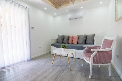 a living room with a couch and a table and chairs at GardenLux Vrdnik in Vrdnik