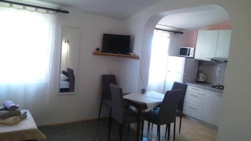 kuchnia ze stołem i krzesłami w pokoju w obiekcie Apartments Ninske Vodice w Nin