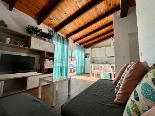 ein Wohnzimmer mit Sofa und Fernseher in der Unterkunft Denia, playa y ciudad in Denia