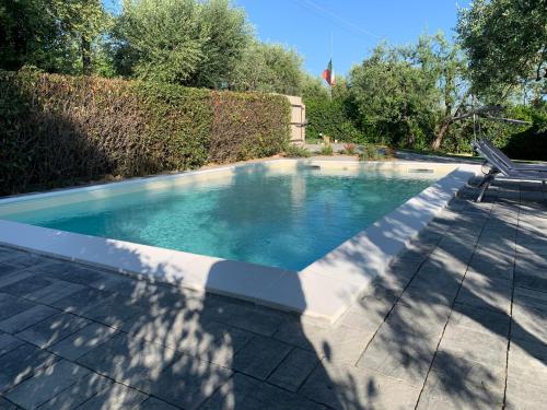 a swimming pool with a bench in a yard at Locazione turistica Casa olivo in Fucecchio
