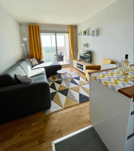 un salon avec un canapé et une table dans l'établissement Appartement calme et propre avec vue sur la mer, à Saint-Laurent-du-Var