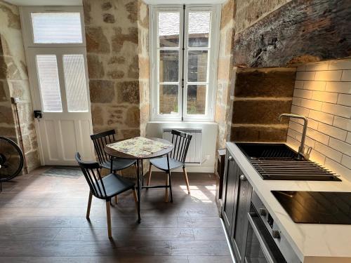 een keuken met een tafel en stoelen en een fornuis bij Treignac Place Studio in Treignac