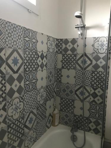 La salle de bains est pourvue d'une douche et de carrelage sur le mur. dans l'établissement Belle chambre privée Cergy (dans le golf) proche RER A, à Vauréal