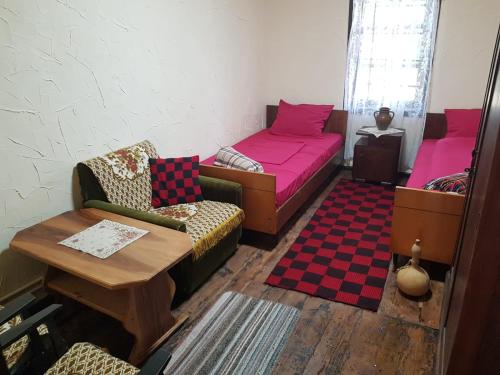 a room with two beds and a couch and a table at Konaciste Mali Izvor in Boljevac