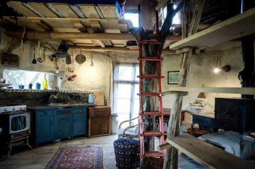 una cocina con una escalera en el medio de una habitación en slaměný domek, en Bystrá