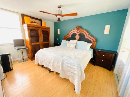 a bedroom with a large bed and a blue wall at Penthouse 6 Panoramic Ocean Views Top Floor in Fort Myers Beach