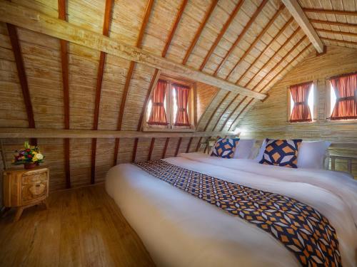um quarto com uma cama num quarto de madeira em Wisnu Lumbung Uluwatu em Uluwatu