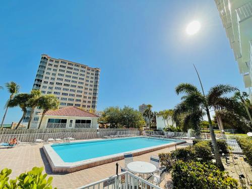 a swimming pool with a building in the background at Penthouse 6 Panoramic Ocean Views Top Floor in Fort Myers Beach