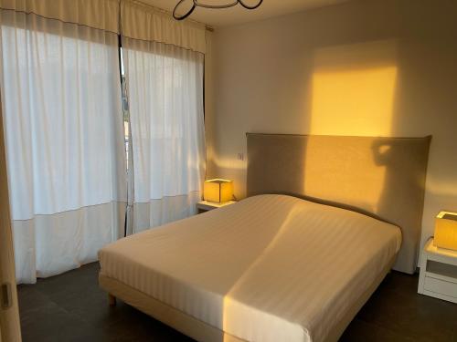 a bedroom with a large white bed and a window at Coucher de soleil in Porticcio