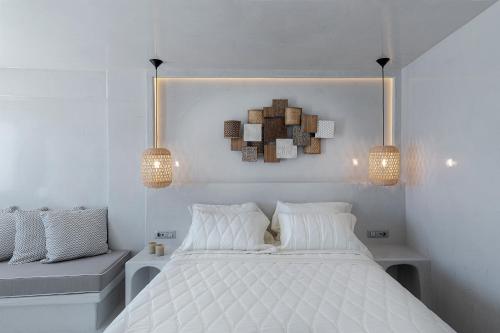 a bedroom with a white bed and two lights at Kaleidoscope Imerovigli Suites in Imerovigli