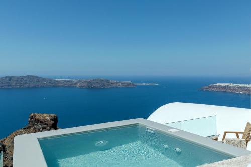 a swimming pool with a view of the ocean at Kaleidoscope Imerovigli Suites in Imerovigli