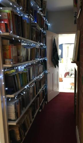 a room with a book shelf filled with books at Cosy 2 bedroom Victorian cottage, Newport, Isle of Wight in Newport
