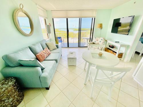 a living room with a couch and a table at #908 Lovers Key Beach Club Gulf View in Fort Myers Beach