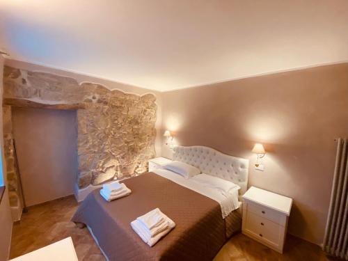 a bedroom with a bed and a stone wall at L’Oca Giuliva Relais in Gaggio Montano
