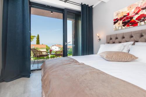 a bedroom with a bed and a large window at Boutique Residence Arion in Rovinj