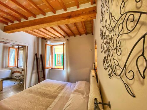 ein Schlafzimmer mit einem Bett und einem Wandgemälde in der Unterkunft Piazzetta Del Buonumore in Montepulciano