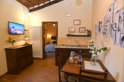 a living room with a table and a kitchen with a sink at il Cantuccio in Pitigliano