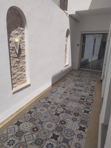 a hallway with a tile floor and a window at Maison Bleu in Hammamet