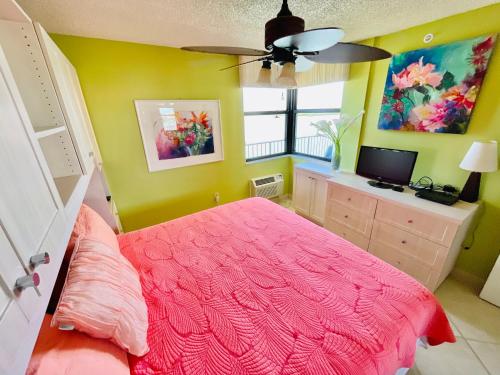a bedroom with a pink bed and a window at #903 Panoramic Ocean View at Lovers Key Beach Club in Fort Myers Beach