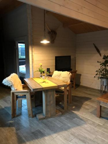 a wooden table and chairs in a room with a television at Chalet peter in Limmen