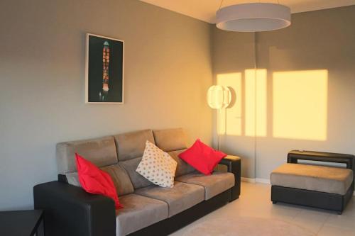 a living room with a brown couch with red pillows at Сomfortable apartments and free garage parking in Porto