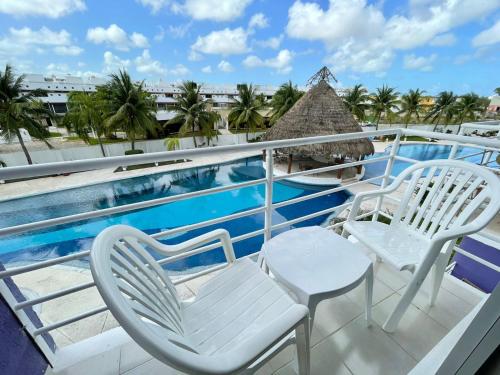 a balcony with two chairs and a swimming pool at Yikal Suites by Andiani Travel in Cancún