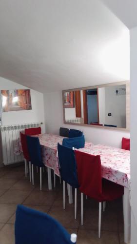 a dining room with red and blue chairs and tables at La Quercia Fiorita in Trivolzio