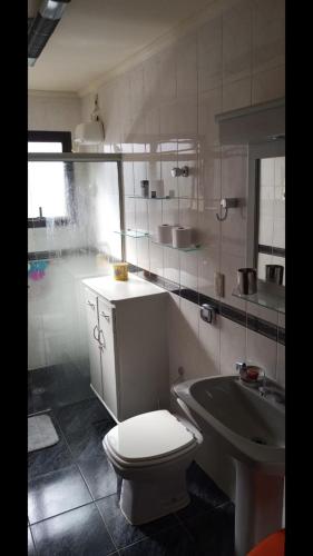 a bathroom with a toilet and a sink at Piemonte Flat Serra Negra in Serra Negra