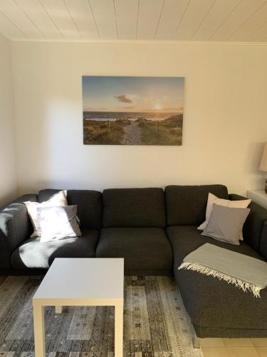 a living room with a couch and a table at Noorhus - Kurzurlaub an der Ostsee in Maasholm