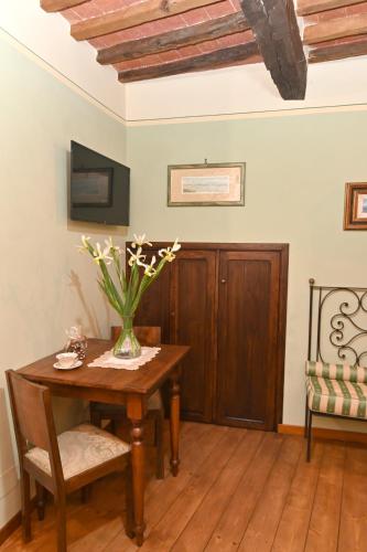 a room with a table with a vase of flowers on it at il Cantuccio in Pitigliano