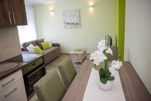 a kitchen and living room with a table with flowers on it at Apartmani San Martin in Sveti Martin na Muri