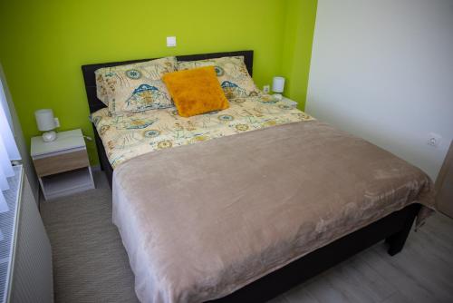 a bedroom with a bed with a yellow pillow on it at Apartmani San Martin in Sveti Martin na Muri
