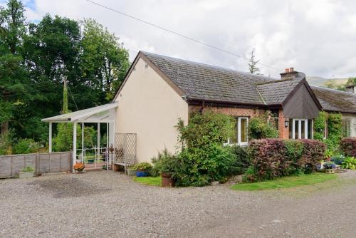 a house with a gravel driveway in front of it at Pinetree Cottage, dog friendly, Holiday let, Callander Invertrossachs in Callander