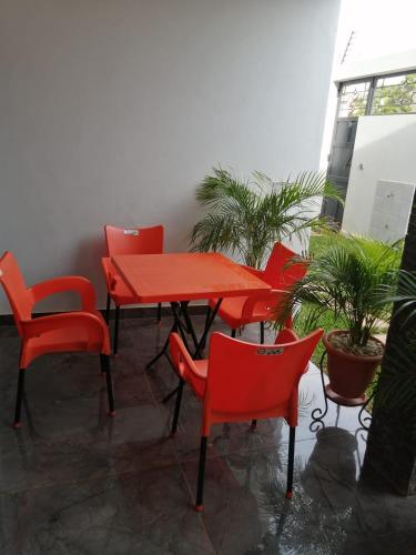 un grupo de mesas y sillas rojas en un patio en RÉSIDENCE HÔTELIÈRE KAWEROU, en Ouagadougou