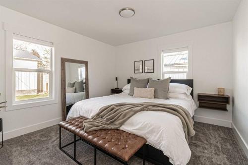 um quarto branco com uma cama grande e um banco em Professionally Designed Central Idaho Falls home - 4 bed 2 bath em Idaho Falls