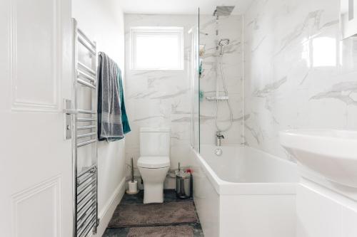 a white bathroom with a toilet and a sink at Private Two Bedroom Residence in Southbourne - Private Parking - Off the High Street - Minutes Away from the Beach in Bournemouth