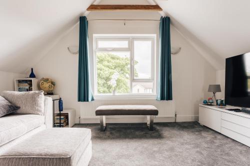 a living room with a couch and a window at Private Two Bedroom Residence in Southbourne - Private Parking - Off the High Street - Minutes Away from the Beach in Bournemouth