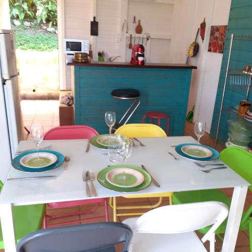 une table avec des assiettes et des verres au-dessus dans l'établissement Bungalow Vernou Petit-Bourg, à Petit-Bourg