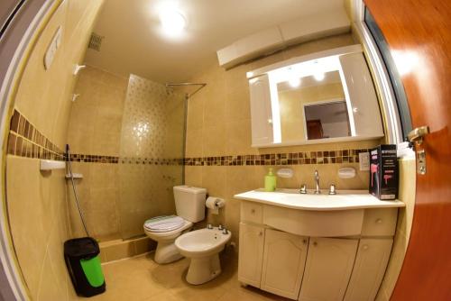 a bathroom with a sink and a toilet and a mirror at Departamento Centro con cochera gratis in Paraná