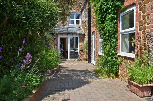 a brick house with a pathway leading to the front door at Honeycomb House Apartments in Hunstanton