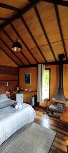 1 dormitorio con 1 cama y fogones en una habitación en Chalés Lanelli en Monte Verde